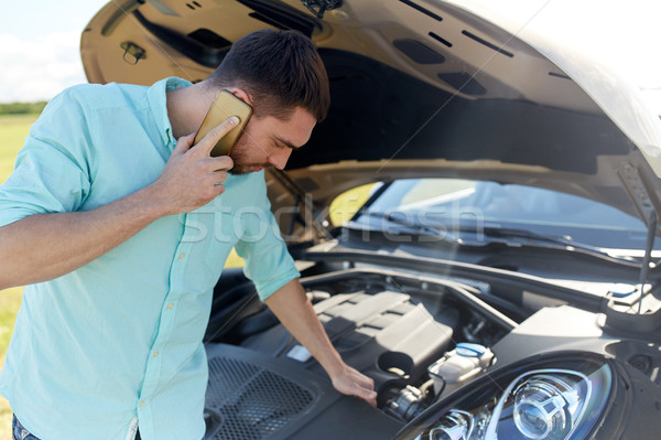 man with broken car calling on smartphone Stock photo © dolgachov