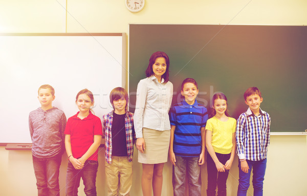 group of school kids and teacher in classroom Stock photo © dolgachov