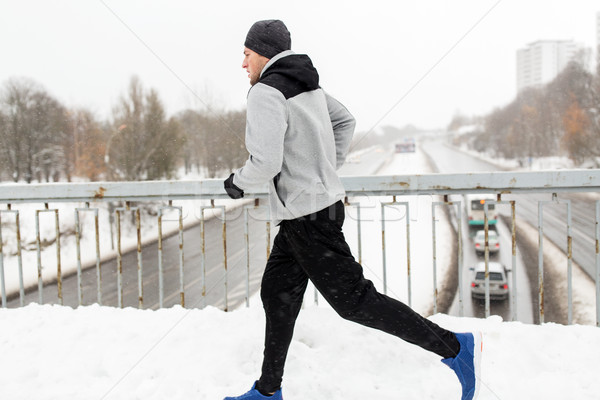 man running along snow covered winter bridge road Stock photo © dolgachov