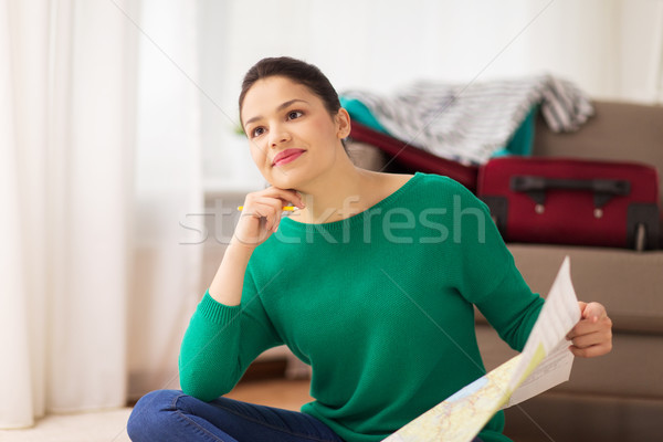 happy young woman with travel map at home Stock photo © dolgachov