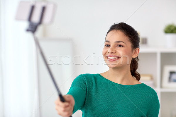 woman taking selfie by smartphone monopod at home Stock photo © dolgachov