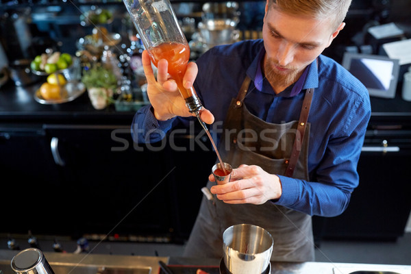 barman pouring alcohol to cocktail jigger at bar Stock photo © dolgachov