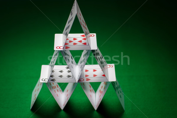house of playing cards on green table cloth Stock photo © dolgachov