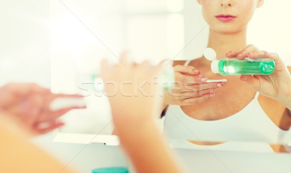 young woman with lotion washing face at bathroom Stock photo © dolgachov