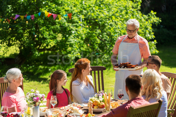 happy family having dinner or summer garden party Stock photo © dolgachov
