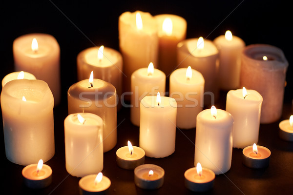 candles burning in darkness over black background Stock photo © dolgachov