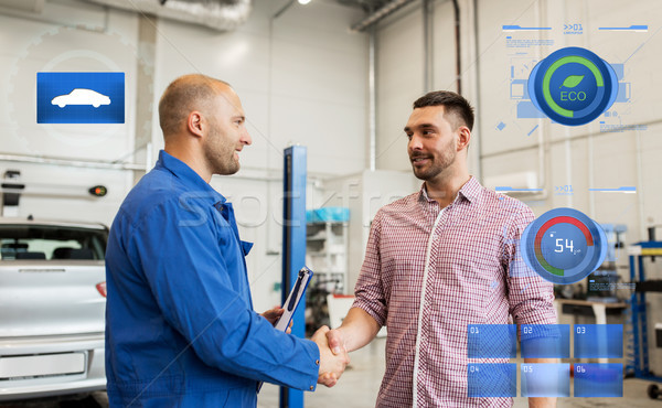 auto mechanic and man shaking hands at car shop Stock photo © dolgachov