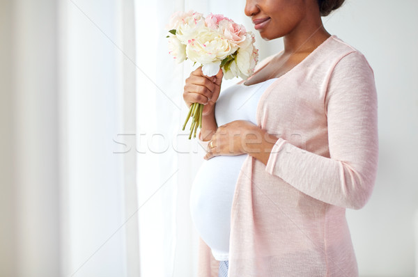 happy african american pregnant woman with flowers Stock photo © dolgachov