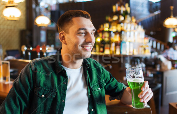 man drinking green beer at bar or pub Stock photo © dolgachov
