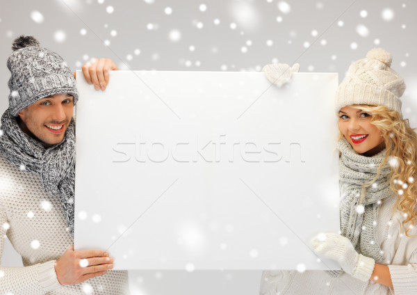 couple in a winter clothes holding blank board Stock photo © dolgachov