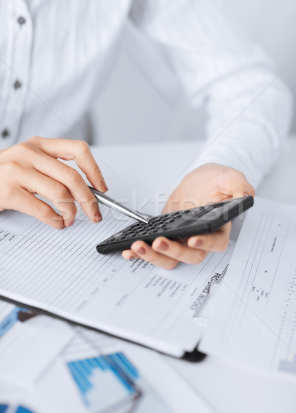 Stock photo: woman hand with calculator and papers