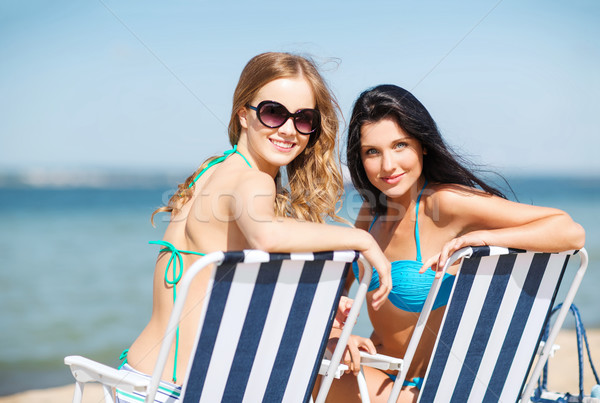 girls sunbathing on the beach chairs Stock photo © dolgachov