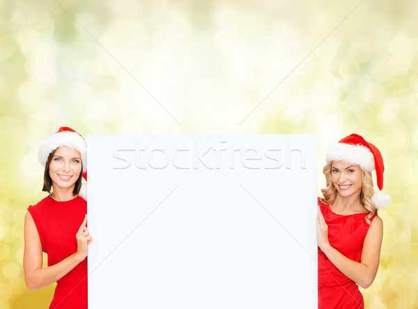 women in santa helper hats with blank white board Stock photo © dolgachov