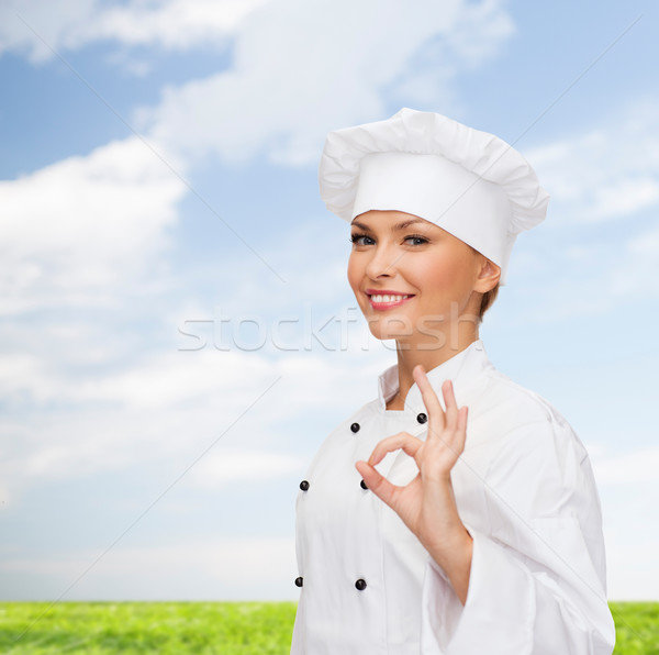 Foto stock: Sonriendo · femenino · chef · muestra · de · la · mano