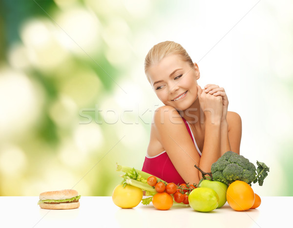 doubting woman with fruits and hamburger Stock photo © dolgachov