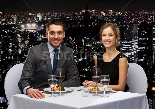 smiling couple eating main course at restaurant Stock photo © dolgachov