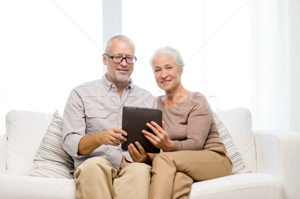 Stock photo: happy senior couple with tablet pc at home