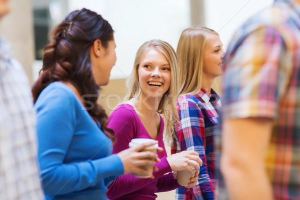 group of smiling students with paper coffee cups Stock photo © dolgachov