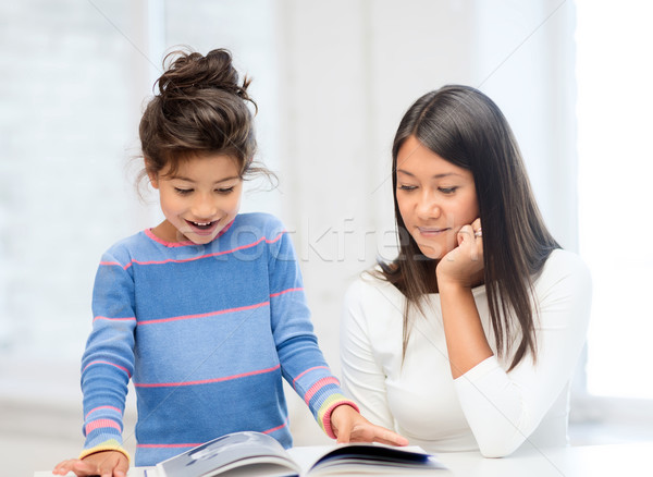 mother and daughter with book Stock photo © dolgachov