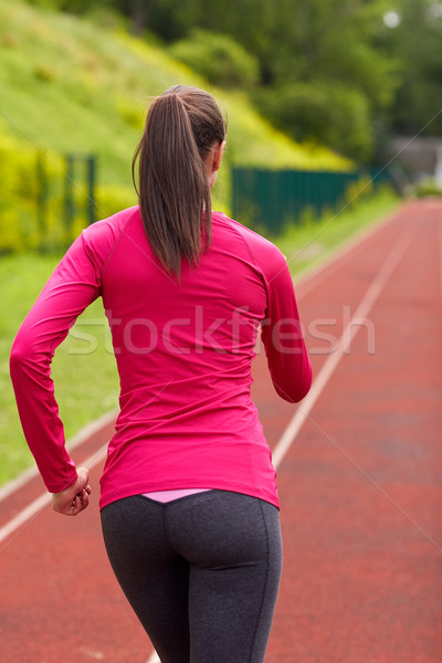 woman running on track outdoors from back Stock photo © dolgachov