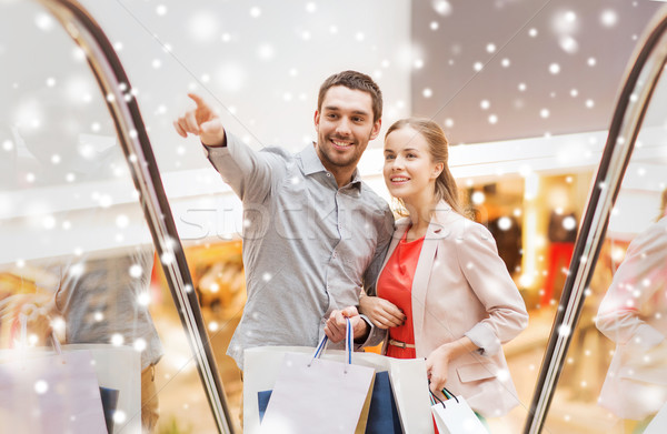 couple with shopping bags on escalator in mall Stock photo © dolgachov