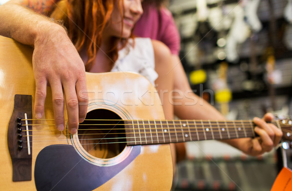 Stock photo: close up of musicians with guitar at music store