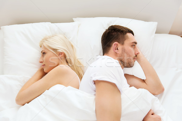 unhappy couple lying in bed at home Stock photo © dolgachov