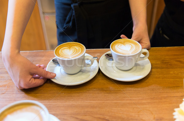 close up of hands with latte art in coffee cup Stock photo © dolgachov