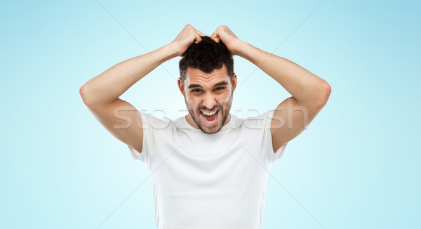 crazy shouting man in t-shirt over blue background Stock photo © dolgachov