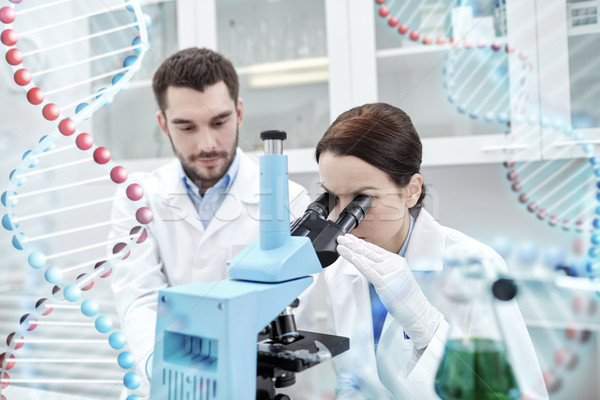 scientists with microscope making test in lab Stock photo © dolgachov