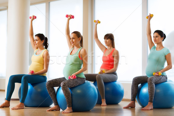 happy pregnant women exercising on fitball in gym Stock photo © dolgachov