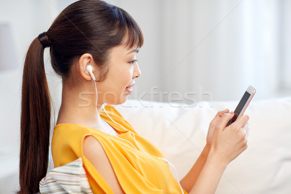 happy asian woman with smartphone and earphones Stock photo © dolgachov