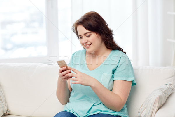 happy plus size woman with smartphone at home Stock photo © dolgachov