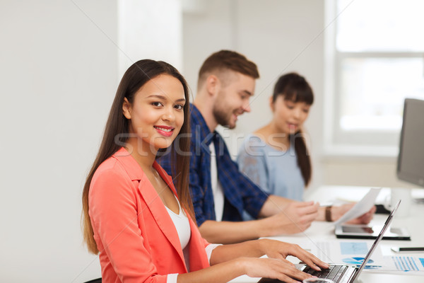 happy african woman over creative team at office Stock photo © dolgachov