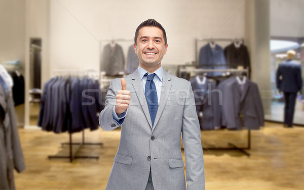 happy businessman in suit over clothing store Stock photo © dolgachov