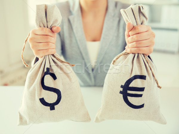 Stock photo: close up of woman hands holding money bags