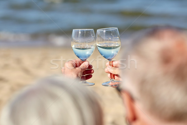 happy senior couple drinking wine on summer beach Stock photo © dolgachov