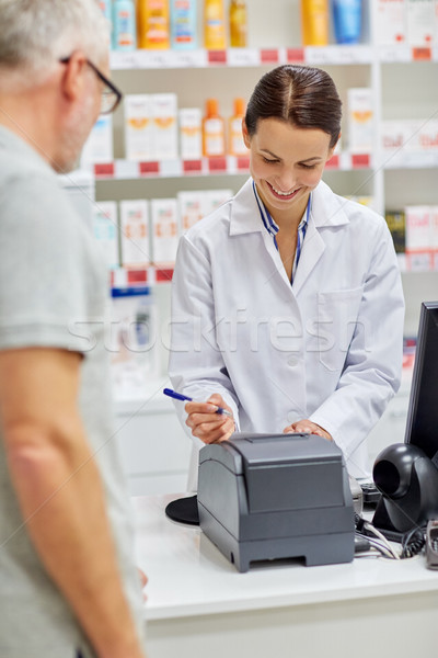 pharmacist writing check for customer at drugstore Stock photo © dolgachov