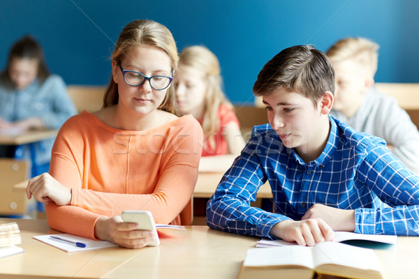 students with smartphone texting at school Stock photo © dolgachov