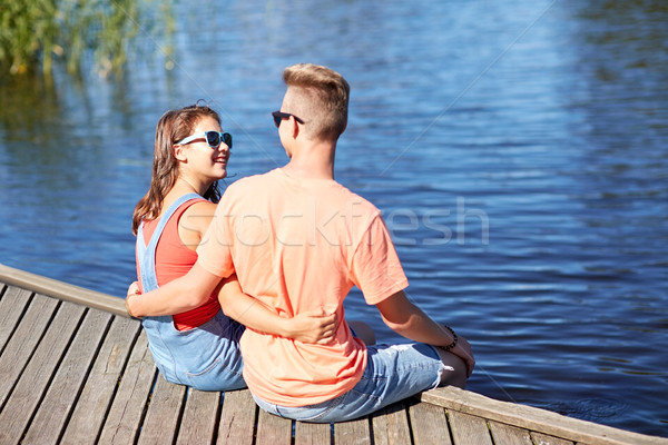 Stock photo: happy teenage couple hugging on river berth