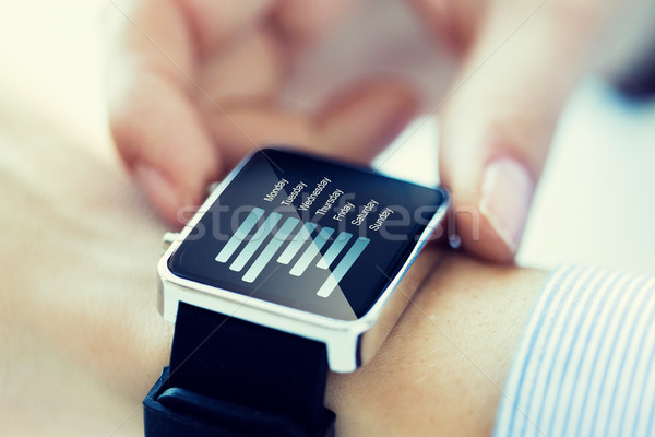close up of hands with chart on smartwatch screen Stock photo © dolgachov