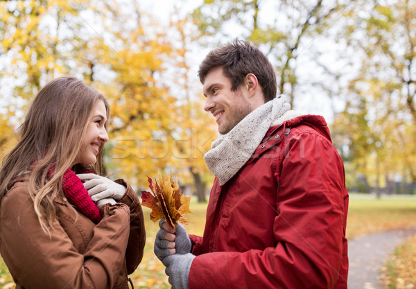 Stock photo: happy couple with maple leaves in autumn park