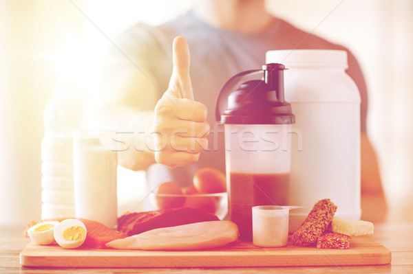 man with protein food showing thumbs up Stock photo © dolgachov