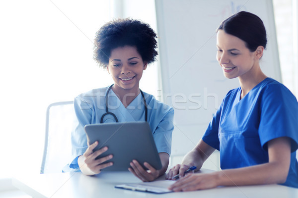 happy doctors with tablet pc meeting at hospital Stock photo © dolgachov