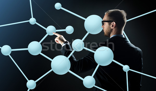 businessman pointing finger to virtual molecule Stock photo © dolgachov