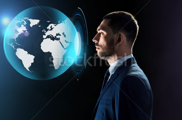 бизнесмен глядя виртуальный земле проекция деловые люди Сток-фото © dolgachov