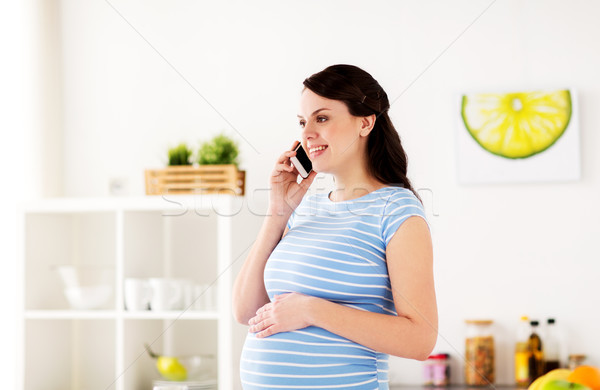 Heureux femme enceinte appelant smartphone maison grossesse [[stock_photo]] © dolgachov