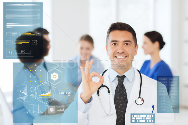 happy doctor showing ok hand sign at hospital Stock photo © dolgachov