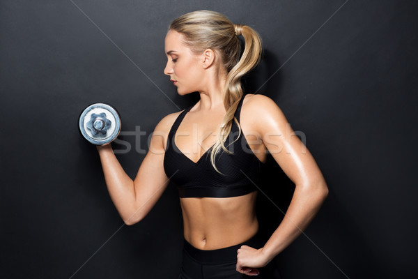 Stock photo: young sporty woman exercising with dumbbell