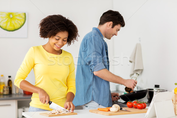 happy couple cooking food at home kitchen Stock photo © dolgachov